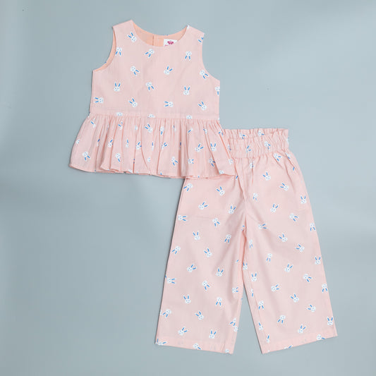 Snuk Kids baby pink two-piece outfit featuring a bunny face print peplum top and matching trousers.