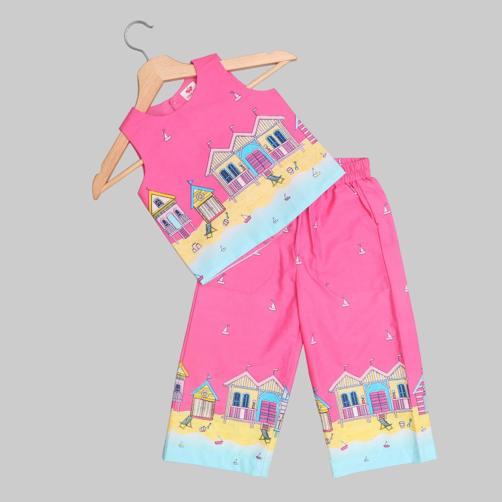 Children's pink outfit with house pattern on a hanger 