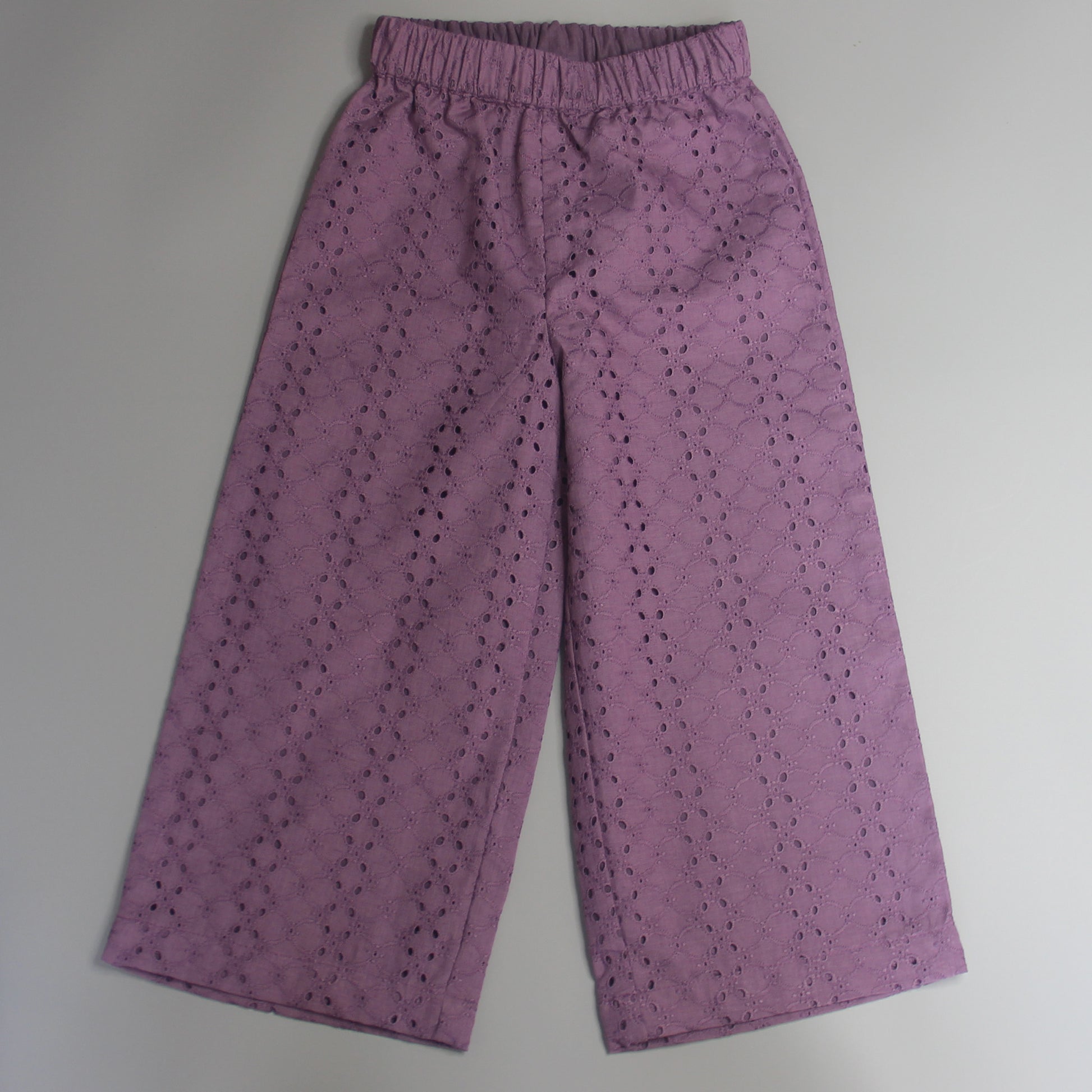 Purple pants with a subtle pattern on a light gray background