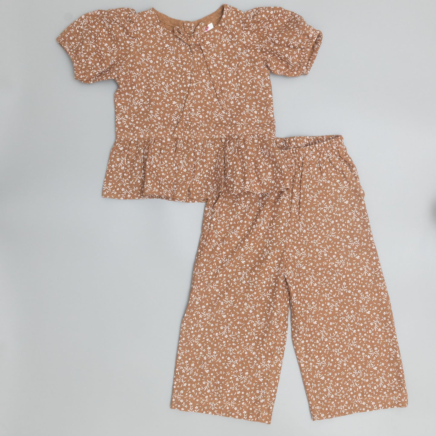 Brown floral outfit with top and pants on a gray background