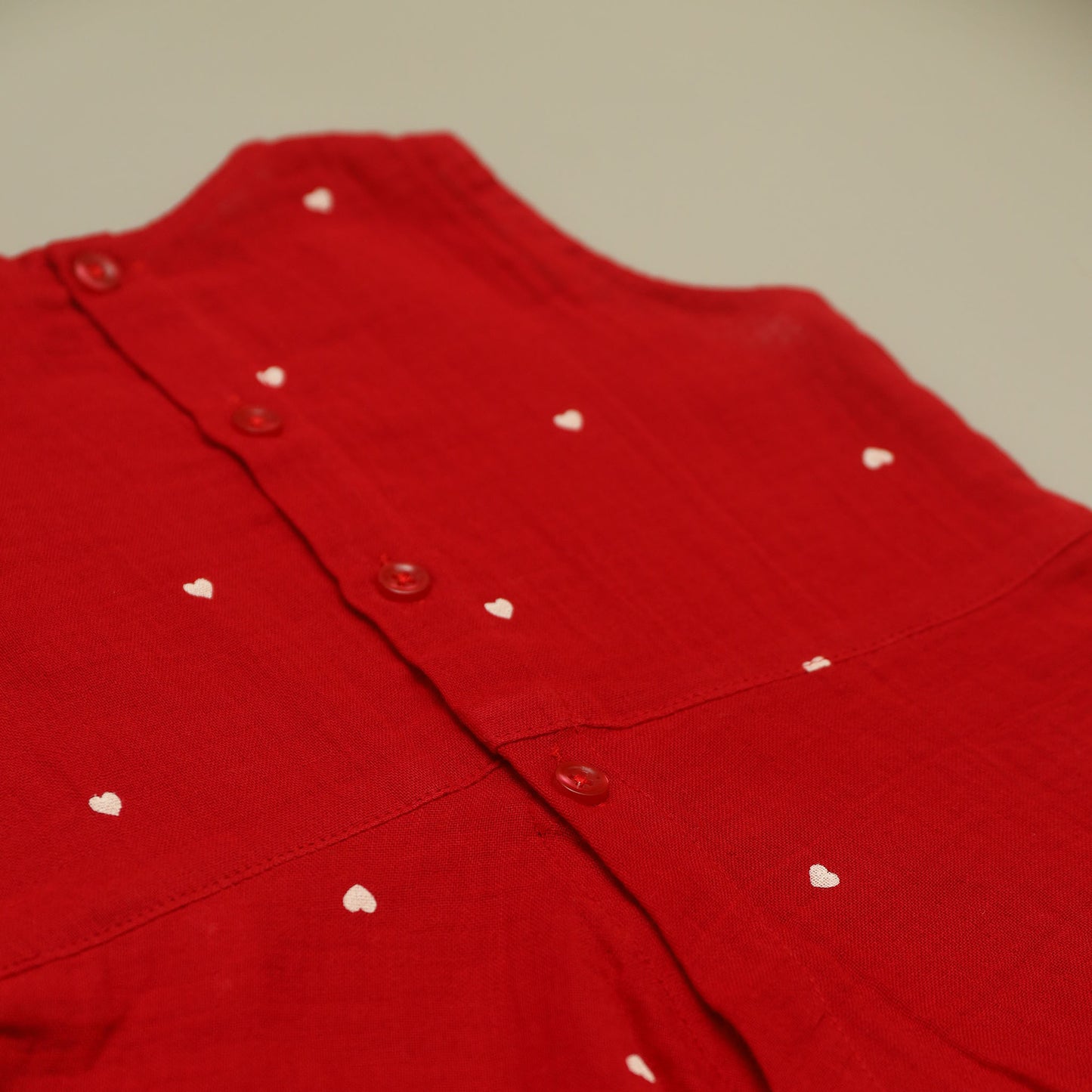 Red garment with white heart patterns on a neutral background