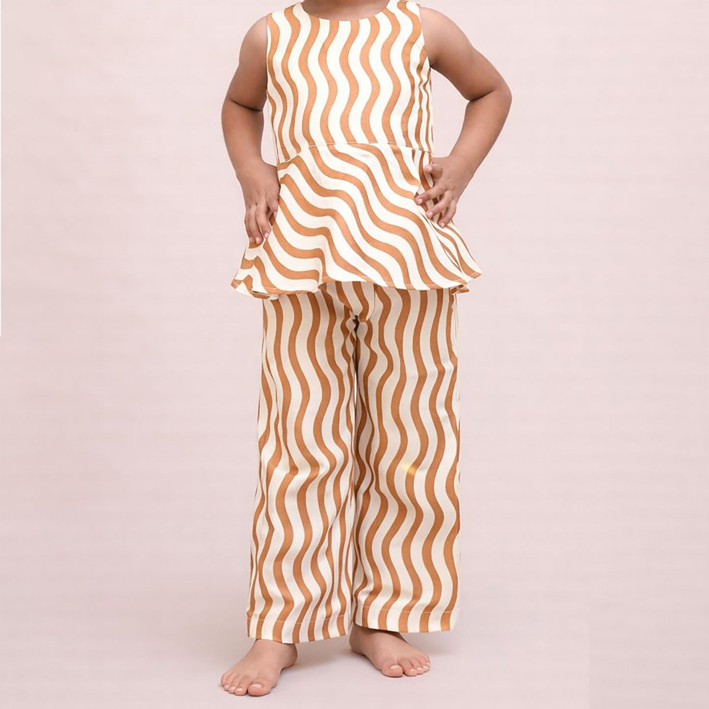 Person wearing a sleeveless top and pants with wavy brown and white pattern