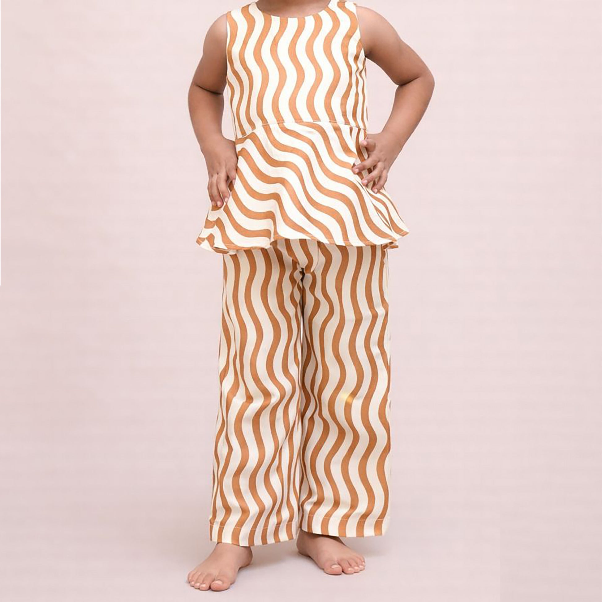 Person wearing a sleeveless top and pants with wavy brown and white pattern